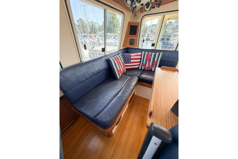 Slide: The Image of Interior of 2007 Island Packet SP Cruiser with blue seating and nautical-themed pillows. - 28