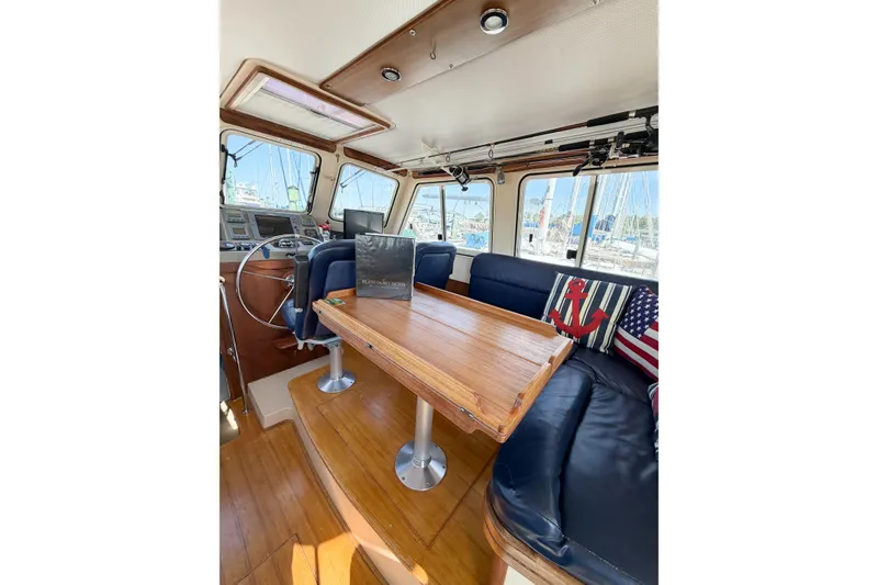 Slide: The Image of Interior of 2007 Island Packet SP Cruiser with wooden table and nautical-themed cushions. - 30