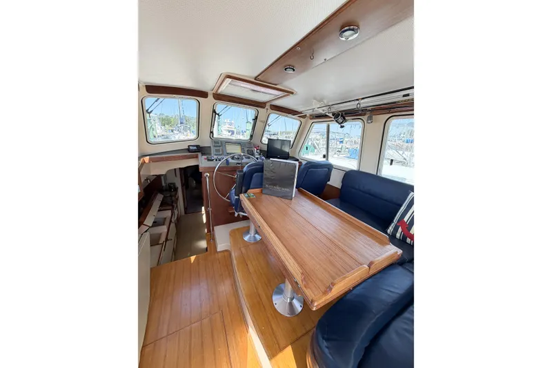 Slide: The Image of Interior of 2007 Island Packet SP Cruiser with wooden table and blue seating. - 32