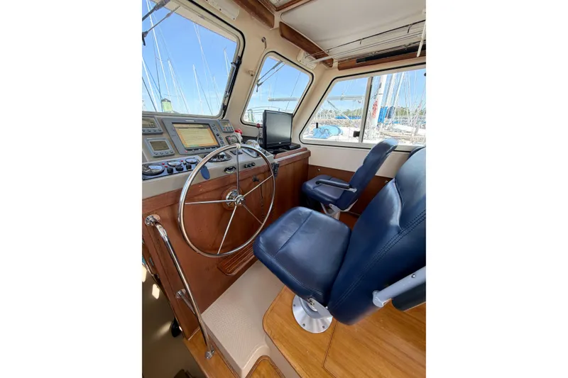 Slide: The Image of 2007 Island Packet SP Cruiser helm with steering wheel, navigation instruments, and blue captain's chair. - 33