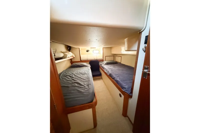 Slide: The Image of Interior cabin of 2007 Island Packet SP Cruiser with twin beds and cozy lighting. - 49