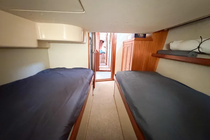 Slide: The Image of 2007 Island Packet SP Cruiser cabin with twin beds and wooden cabinetry. - 51