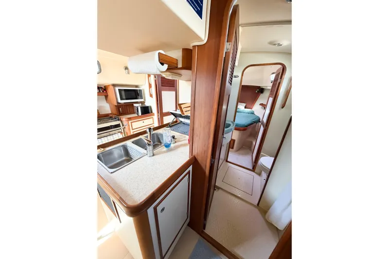 Slide: The Image of 2007 Island Packet SP Cruiser interior with kitchen, sink, and cozy sleeping area. - 55