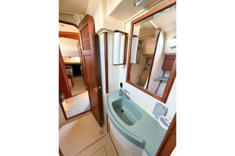 Slide: The Image of 2007 Island Packet SP Cruiser bathroom with sink, mirror, and wooden cabinetry. - 57