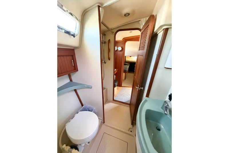 Slide: The Image of 2007 Island Packet SP Cruiser bathroom with toilet, sink, and wooden door. - 58