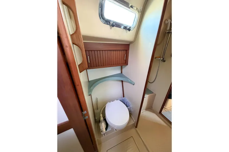 Slide: The Image of 2007 Island Packet SP Cruiser bathroom with toilet, shower, and wooden cabinetry. - 59