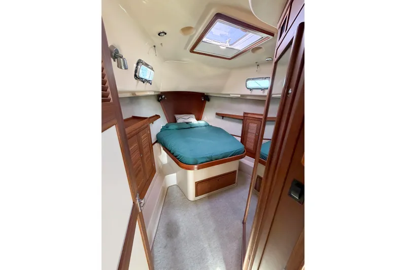 Slide: The Image of Cozy cabin interior of 2007 Island Packet SP Cruiser with bed and wooden cabinetry. - 60