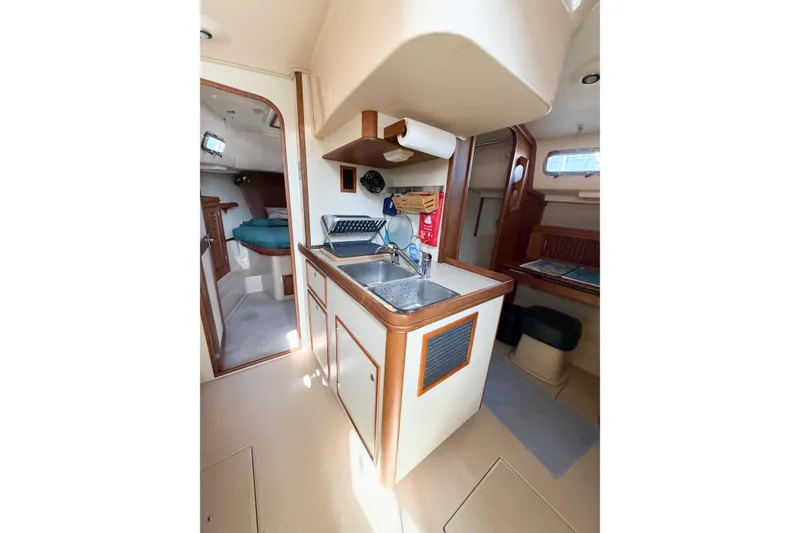 Slide: The Image of 2007 Island Packet SP Cruiser interior with compact kitchen and cozy cabin space. - 65