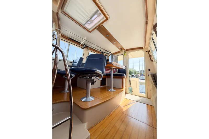 Slide: The Image of 2007 Island Packet SP Cruiser interior with blue seating and wooden flooring. - 69