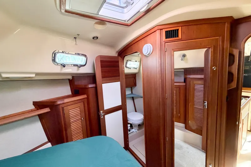 Slide: The Image of 2007 Island Packet SP Cruiser interior with wood finish and compact bathroom. - 71