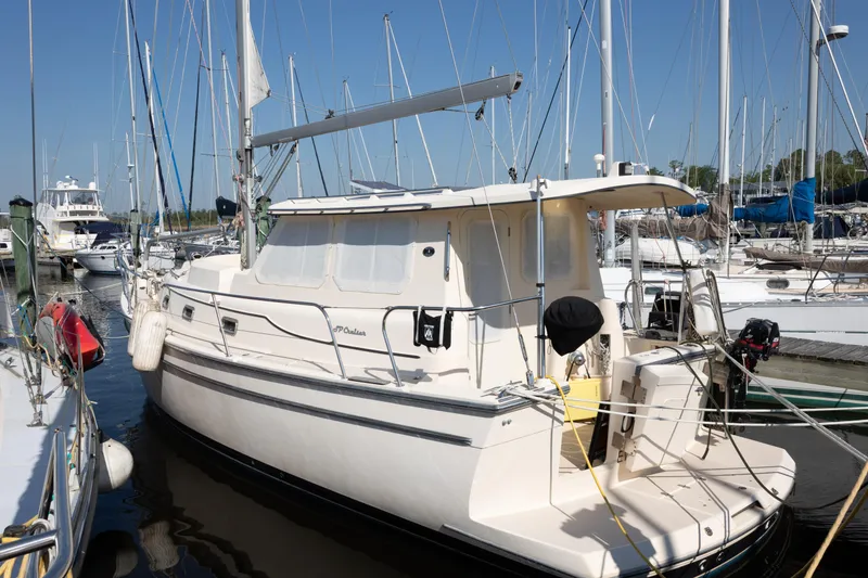 Slide: The Image of 2007 Island Packet SP Cruiser yacht docked at marina, surrounded by sailboats under clear blue sky. - 81