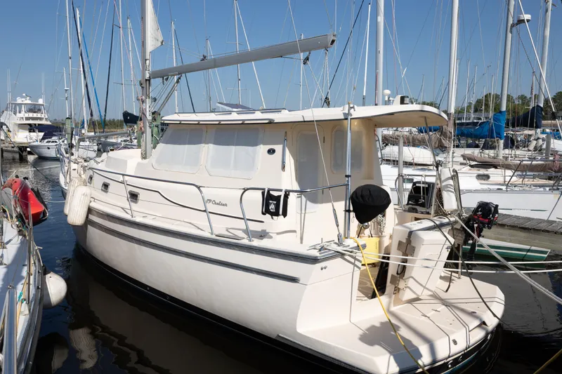 Slide: The Image of 2007 Island Packet SP Cruiser sailboat docked in a marina, surrounded by other boats. - 86
