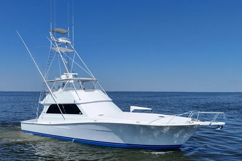 The Image of 1997 Viking 58 Convertible yacht cruising on open water under clear blue sky. - 0