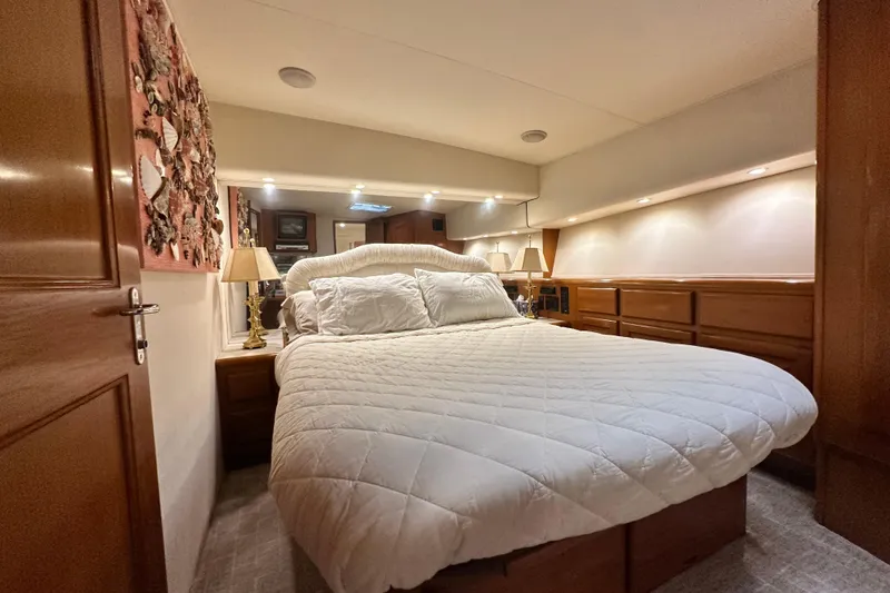 Slide: The Image of Luxurious bedroom interior of a 1997 Viking 58 Convertible yacht with cozy bedding. - 100