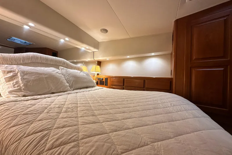 Slide: The Image of Luxurious bedroom interior of a 1997 Viking 58 Convertible yacht with cozy bedding. - 107