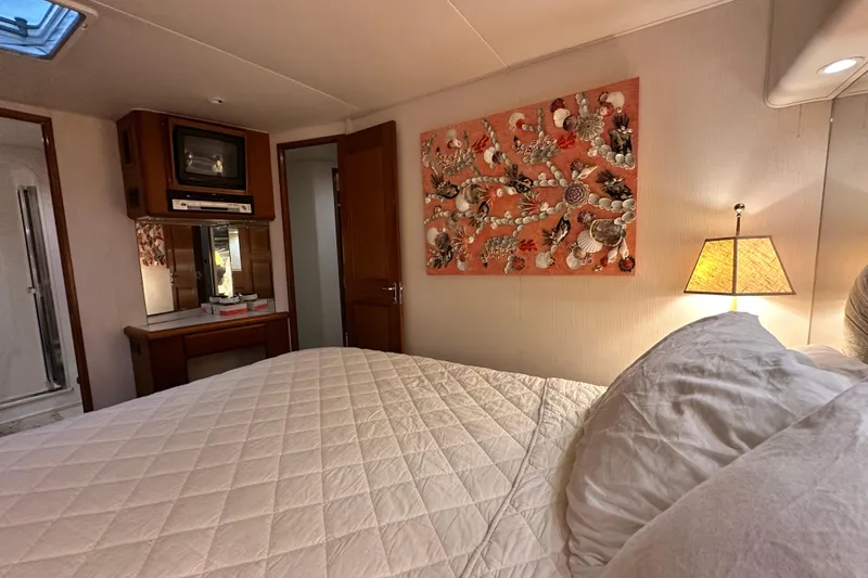 Slide: The Image of Cozy bedroom in 1997 Viking 58 Convertible yacht with quilted bedding and decorative wall art. - 108
