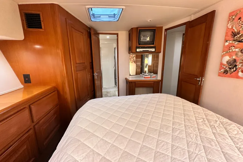 Slide: The Image of Luxurious interior of a 1997 Viking 58 Convertible yacht with wood finishes and cozy bedding. - 109
