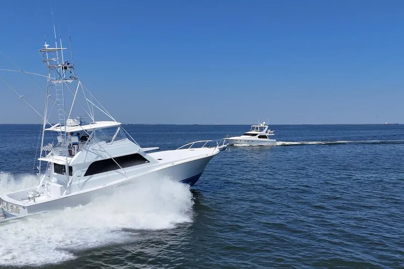 Slide: The Image of Two Viking 58 Convertible yachts cruising on open water under a clear blue sky. - 11
