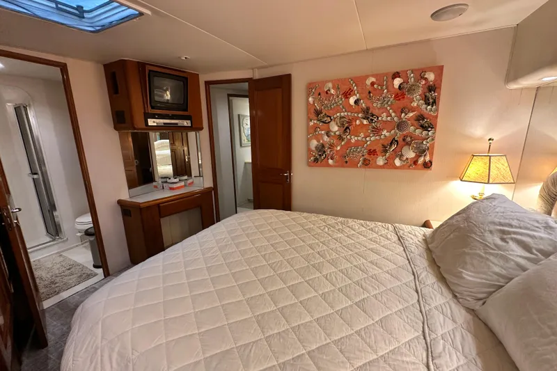 Slide: The Image of Cozy bedroom in 1997 Viking 58 Convertible yacht with quilted bedding and nautical decor. - 110