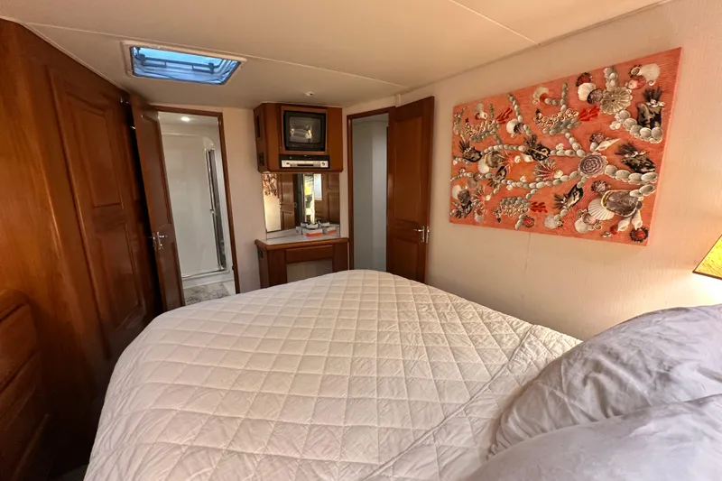 Slide: The Image of Cozy bedroom in 1997 Viking 58 Convertible yacht with quilted bedding and decorative wall art. - 111
