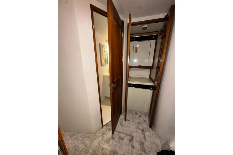 Slide: The Image of Laundry area inside 1997 Viking 58 Convertible yacht, featuring stacked washer and dryer. - 122