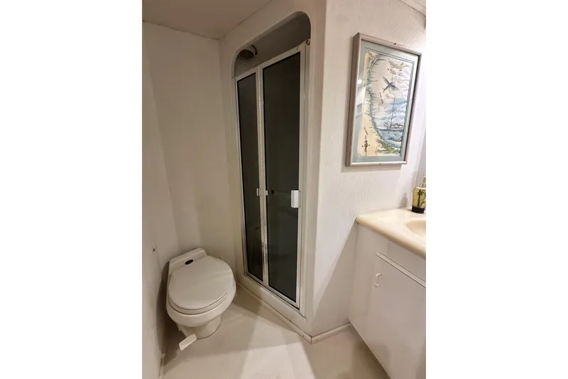 Slide: The Image of Bathroom interior of 1997 Viking 58 Convertible yacht with shower, toilet, and map artwork. - 123