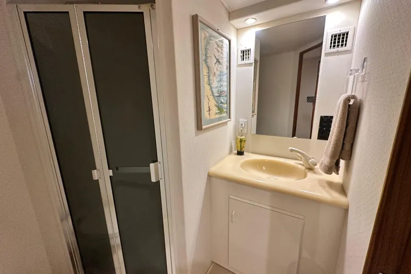Slide: The Image of Bathroom interior of 1997 Viking 58 Convertible yacht with sink, mirror, and shower. - 126