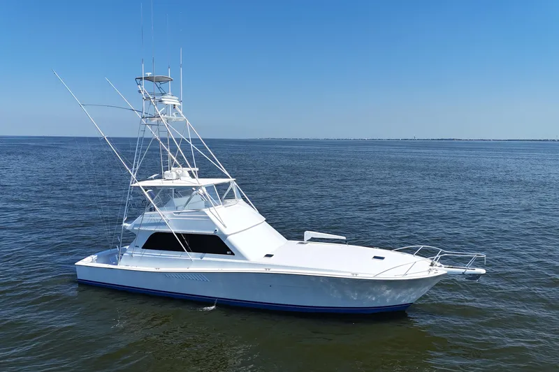 Slide: The Image of 1997 Viking 58 Convertible yacht on open water under clear blue sky. - 13