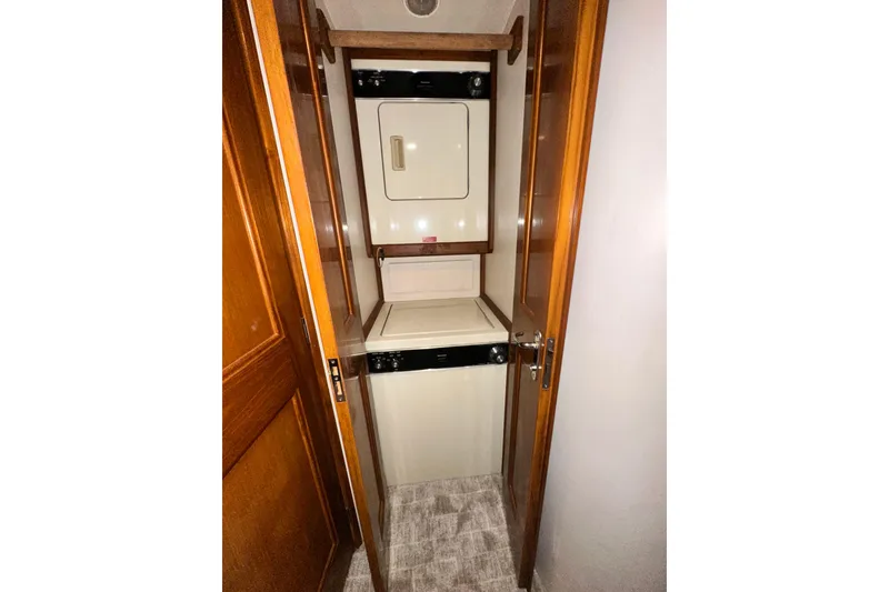 Slide: The Image of Laundry area inside 1997 Viking 58 Convertible yacht with stacked washer and dryer. - 131