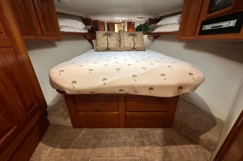 Slide: The Image of Cozy bedroom in 1997 Viking 58 Convertible yacht with palm-themed bedding and wooden cabinetry. - 134