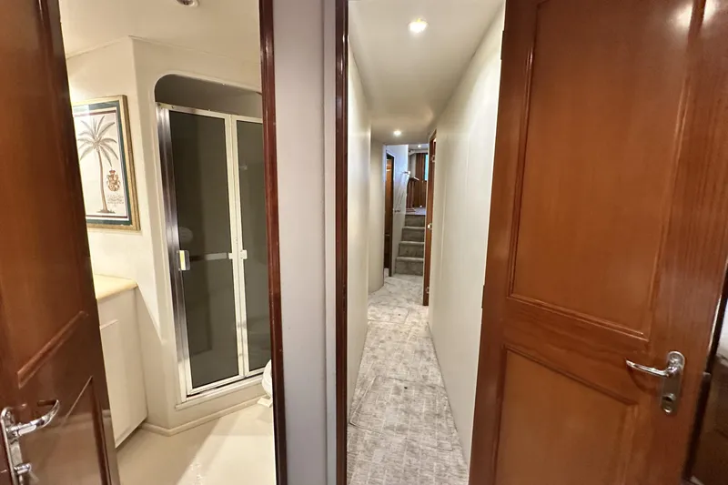 Slide: The Image of Interior hallway of a 1997 Viking 58 Convertible yacht with wooden doors and carpeted floor. - 139