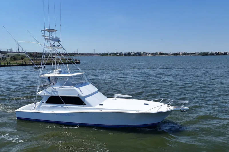 Slide: The Image of 1997 Viking 58 Convertible yacht cruising on a sunny day in open waters. - 14
