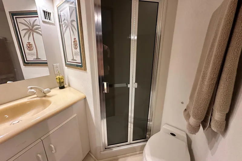 Slide: The Image of Bathroom interior of 1997 Viking 58 Convertible yacht with shower, sink, and decor. - 144