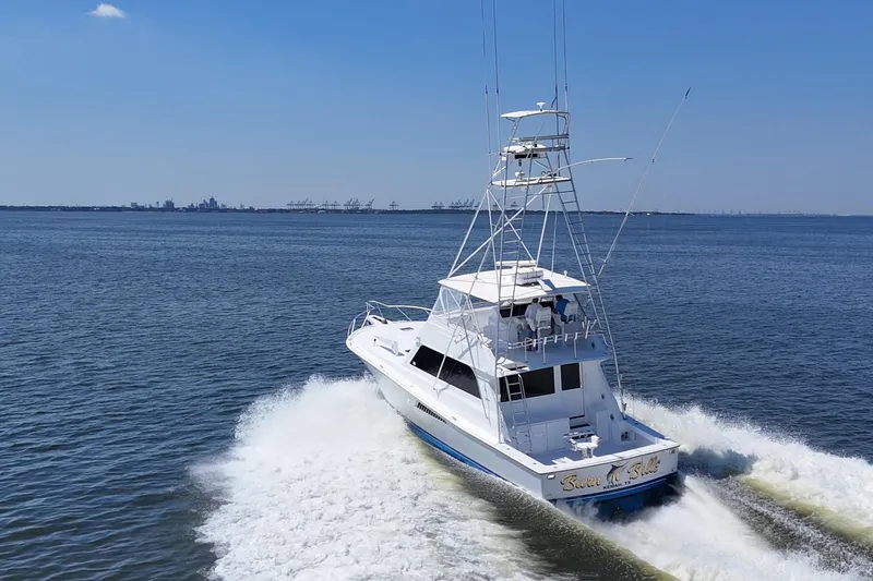 Slide: The Image of 1997 Viking 58 Convertible yacht cruising on open water under clear blue skies. - 15