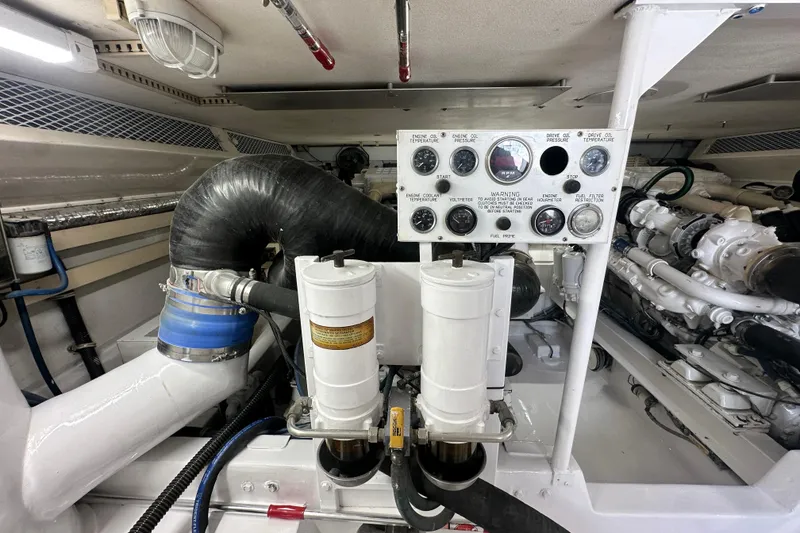 Slide: The Image of Engine room of a 1997 Viking 58 Convertible yacht, featuring gauges and filters. - 154