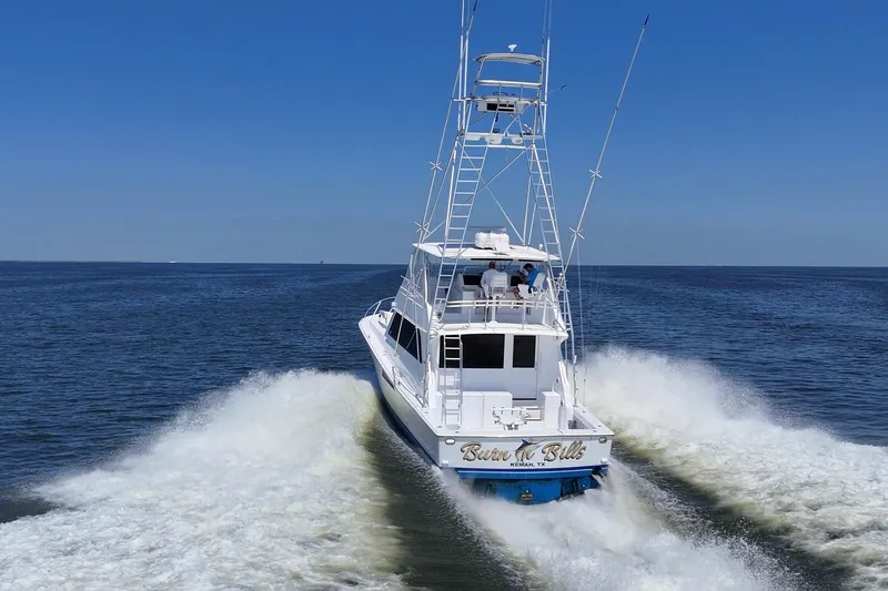 Slide: The Image of 1997 Viking 58 Convertible yacht cruising on open water under clear blue skies. - 16