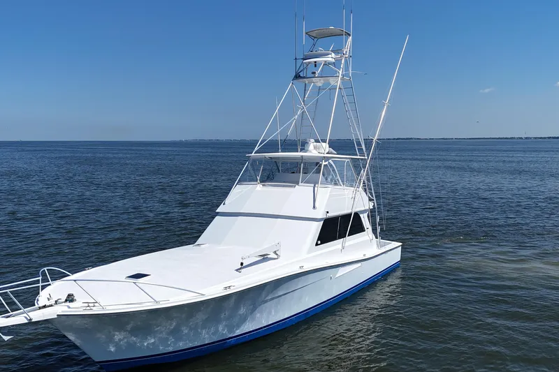 Slide: The Image of 1997 Viking 58 Convertible yacht on calm ocean waters under clear blue sky. - 17