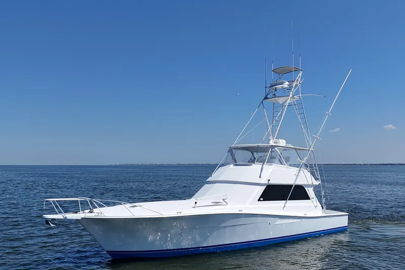 Slide: The Image of 1997 Viking 58 Convertible yacht on calm ocean under clear blue sky. - 18