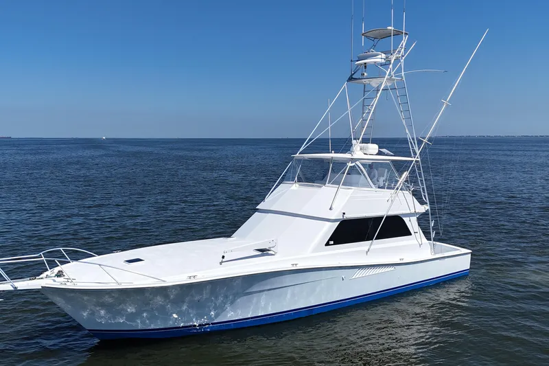 Slide: The Image of 1997 Viking 58 Convertible yacht on calm ocean waters under clear blue sky. - 19
