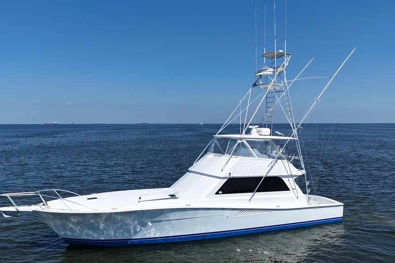 Slide: The Image of 1997 Viking 58 Convertible yacht on calm ocean waters under clear blue sky. - 20