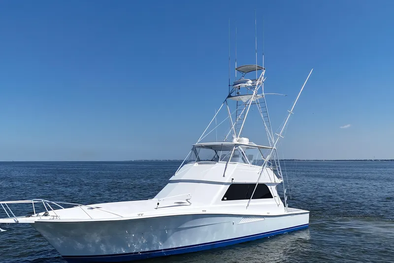 Slide: The Image of 1997 Viking 58 Convertible yacht on calm blue waters under clear sky. - 21