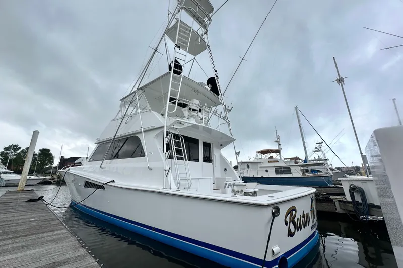 Slide: The Image of 1997 Viking 58 Convertible yacht docked at marina under cloudy skies. - 28