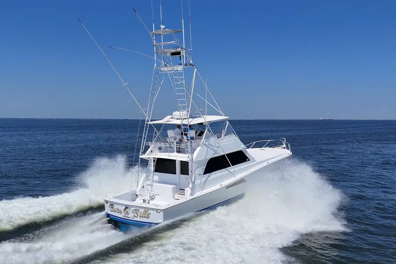 Slide: The Image of 1997 Viking 58 Convertible yacht cruising on open water, creating a dynamic wake. - 3