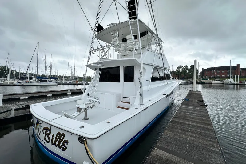 Slide: The Image of 1997 Viking 58 Convertible yacht docked at marina under cloudy skies. - 30