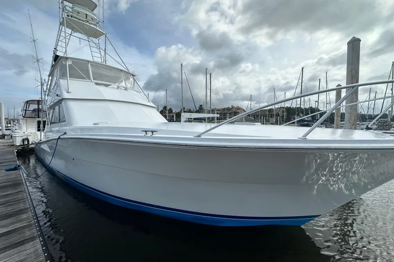 Slide: The Image of 1997 Viking 58 Convertible yacht docked at marina under cloudy sky. - 33