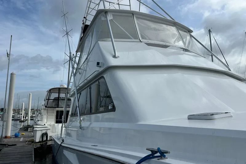 Slide: The Image of 1997 Viking 58 Convertible yacht docked at marina under cloudy sky. - 34
