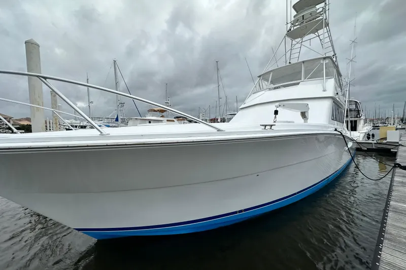 Slide: The Image of 1997 Viking 58 Convertible yacht docked at marina under cloudy skies. - 35