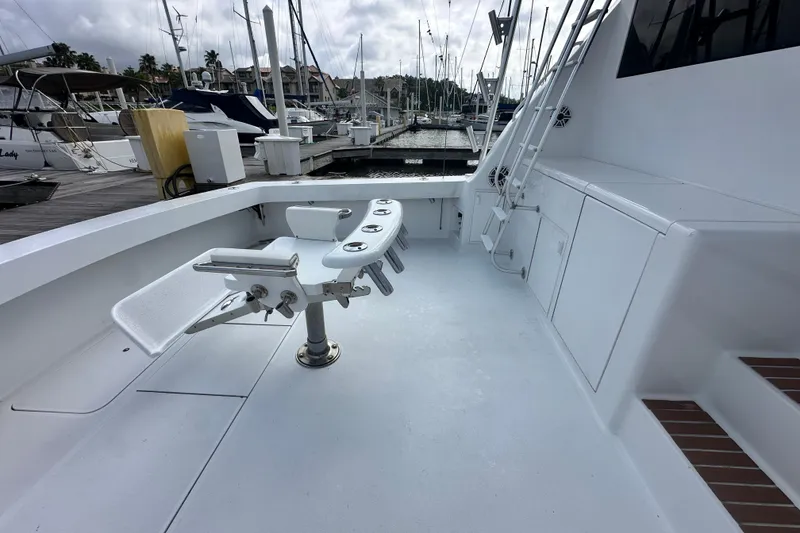 Slide: The Image of 1997 Viking 58 Convertible yacht deck with fishing chair and marina view. - 36