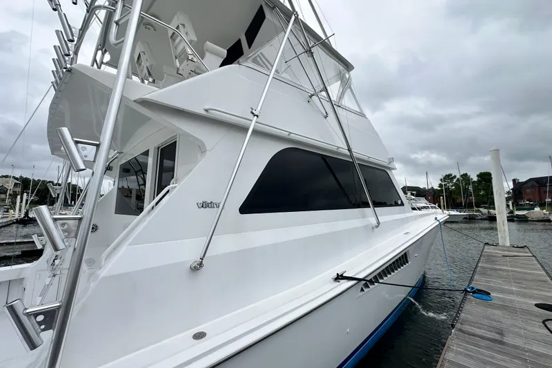 Slide: The Image of 1997 Viking 58 Convertible yacht docked at marina under cloudy skies. - 37