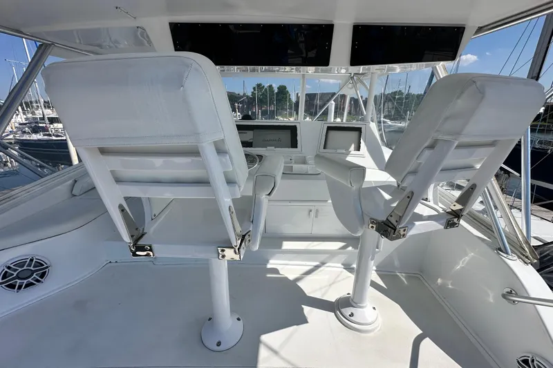 Slide: The Image of 1997 Viking 58 Convertible yacht helm with dual white captain chairs and navigation screens. - 43